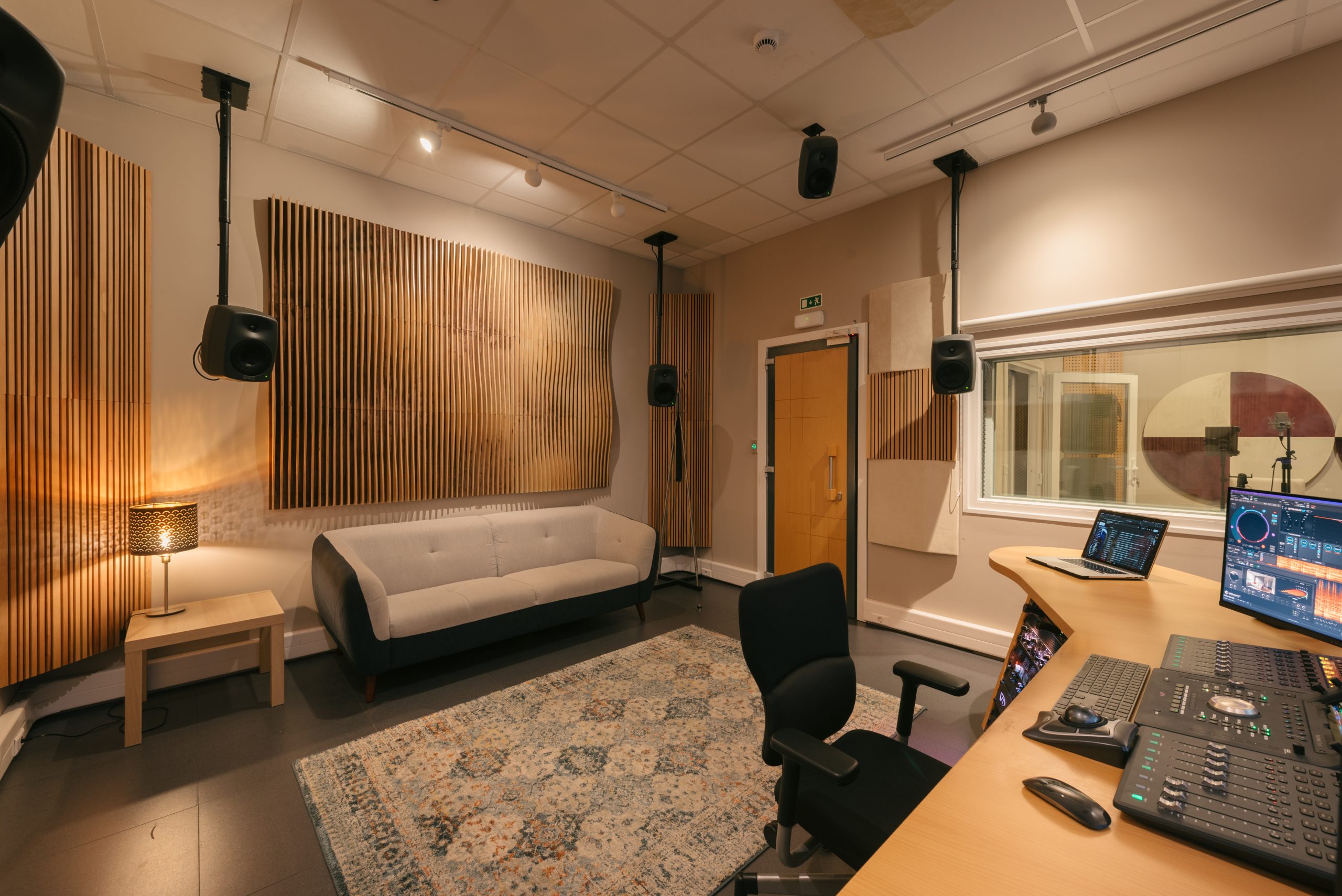 Fotografia lateral do estúdio de som principal da Billyboom - Sound Design com pormenor da cabine de som e do sofá